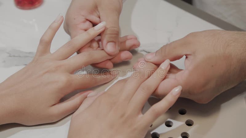Berufsmeister, der die Finger eines Mädchens nach einem Maniküreverfahren massiert