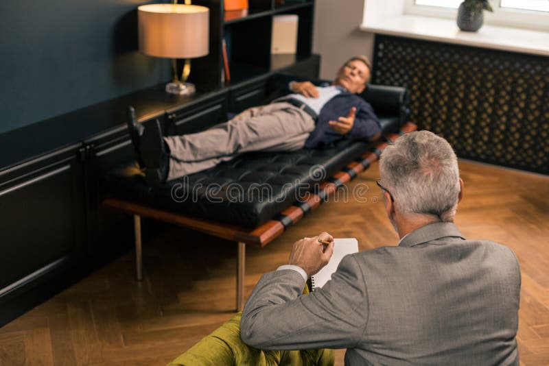 Berufspsychologe, der auf einen Patienten sitzt und hört lizenzfreies stockbild Berufspsychologe, der auf einen Patienten sitzt und hört lizenzfreies stockbild
