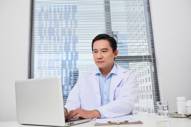 ?berzeugter m?nnlicher Doktor mit Stethoskopfunktion im B?ro stockfoto ?berzeugter m?nnlicher Doktor mit Stethoskopfunktion im B?ro stockfoto
