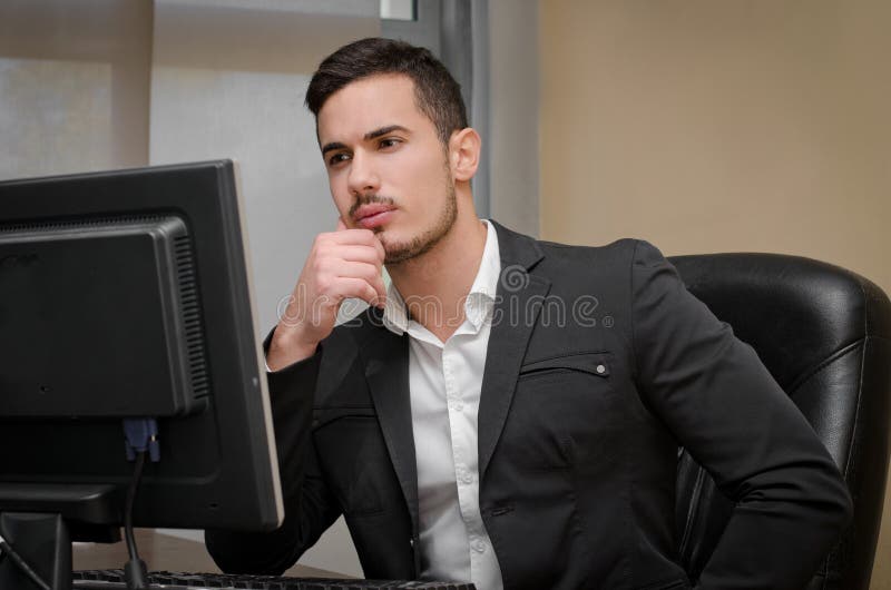 Beschäftigter, besorgter junger männlicher Büroangestellter stockfoto Beschäftigter, besorgter junger männlicher Büroangestellter stockfoto