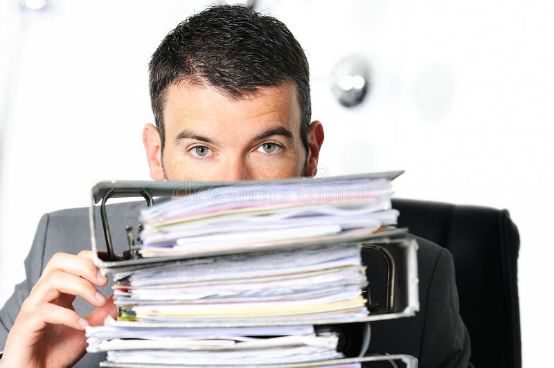 Busy man hiding behind a stack of files. Busy man hiding behind a stack of files