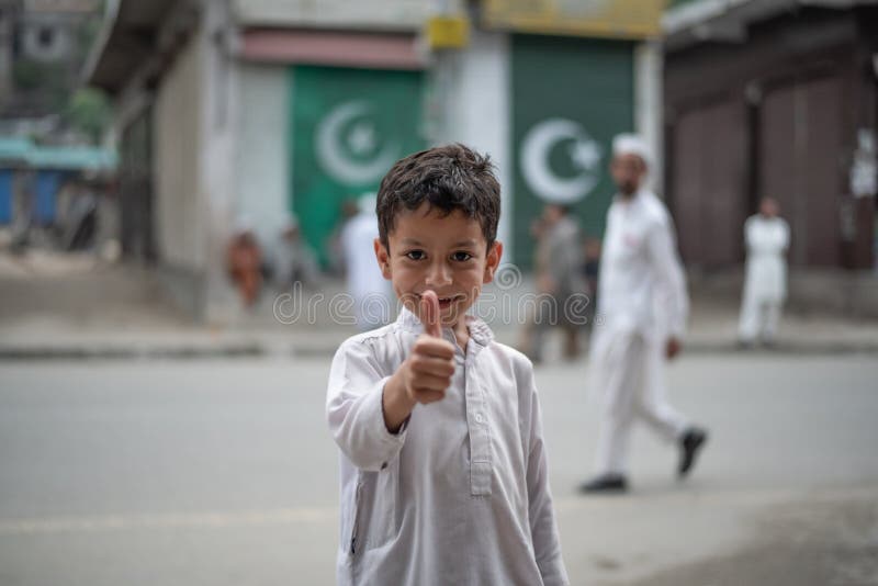 Besham pakistan 15 april 2018 : unbekannter kleiner Junge, der lächelt und auf der Straße Daumen zeigt
