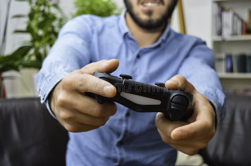 Beslutsam ung stilig maninnehavkontrollant och försöka hårt att segra på videospel royaltyfria foton Beslutsam ung stilig maninnehavkontrollant och försöka hårt att segra på videospel royaltyfria foton
