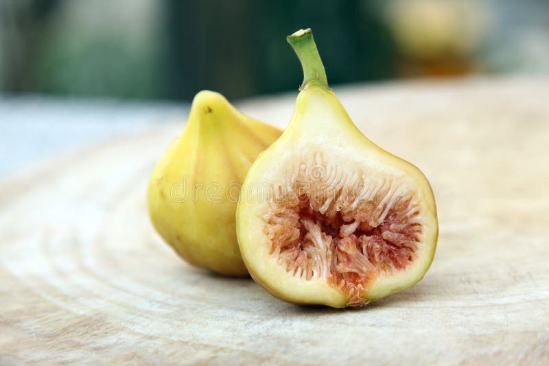 Besnoeiing door van rijp geel fig.fruit op onduidelijk beeldachtergrond royalty-vrije stock foto's Besnoeiing door van rijp geel fig.fruit op onduidelijk beeldachtergrond royalty-vrije stock foto's