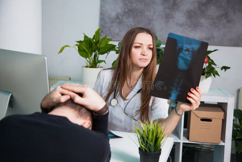 Besorgte medizinische Arbeitskraft mit geduldigem ` s Röntgenstrahl schoss im Klinikbüro stockfotos Besorgte medizinische Arbeitskraft mit geduldigem ` s Röntgenstrahl schoss im Klinikbüro stockfotos
