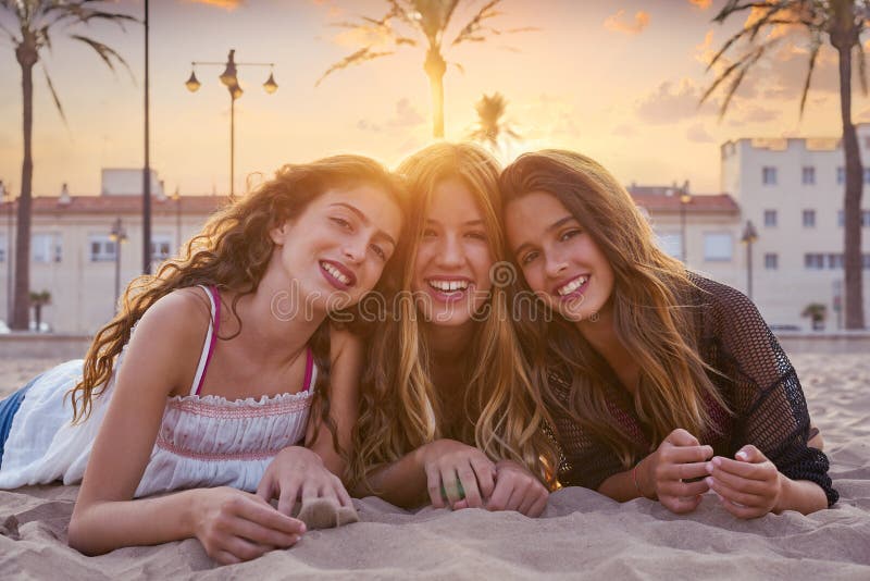 Best friends girls at sunset beach sand