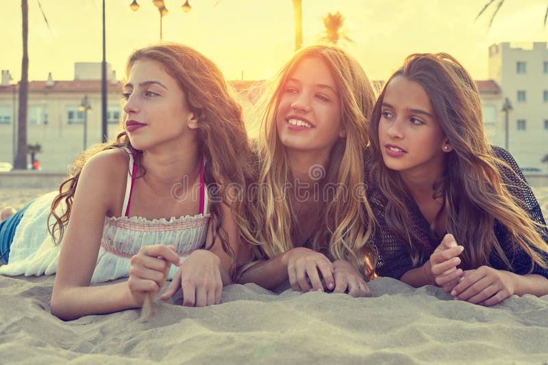 Best friends girls at sunset beach sand