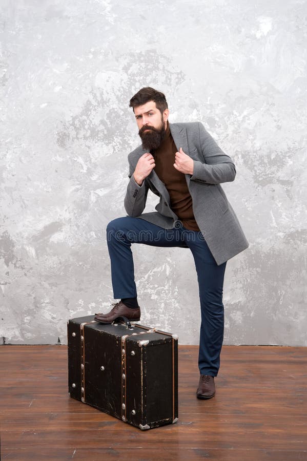 Best travel bags for men. Guy well groomed elegant bearded man and vintage suitcase. Time traveller concept. Vintage stock photography Best travel bags for men. Guy well groomed elegant bearded man and vintage suitcase. Time traveller concept. Vintage stock photography