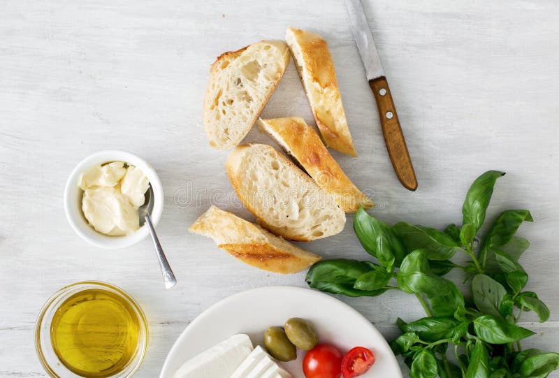 Bestandteile für das Kochen des italienischen bruschetta auf weißem Holztisch lizenzfreies stockfoto Bestandteile für das Kochen des italienischen bruschetta auf weißem Holztisch lizenzfreies stockfoto