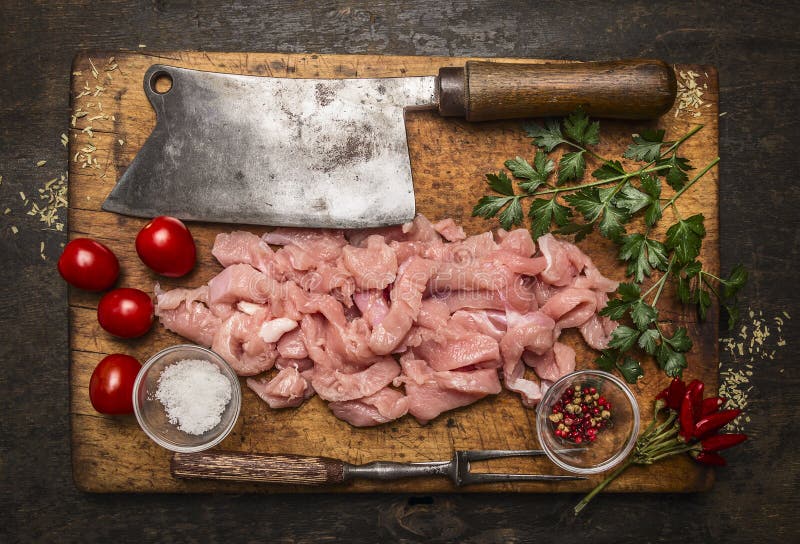 Bestandteile für das Kochen eines Truthahns, Fleischbeil, Fleischgabel, Salz, Pfeffer auf einem hölzernen Schneidebrett auf rusti lizenzfreies stockbild Bestandteile für das Kochen eines Truthahns, Fleischbeil, Fleischgabel, Salz, Pfeffer auf einem hölzernen Schneidebrett auf rusti lizenzfreies stockbild