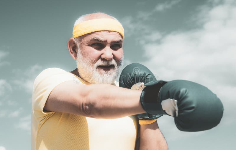 Beste cardio-workout. bejaarde man die de tas raakt. gezonde vechter oudere man bokshandschoenen. boxer met boksen