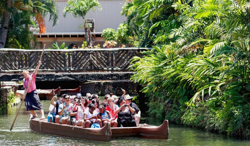 Besökare till den Polynesian kulturella mitten paddlas ner ström på en kanot royaltyfria bilder Besökare till den Polynesian kulturella mitten paddlas ner ström på en kanot royaltyfria bilder