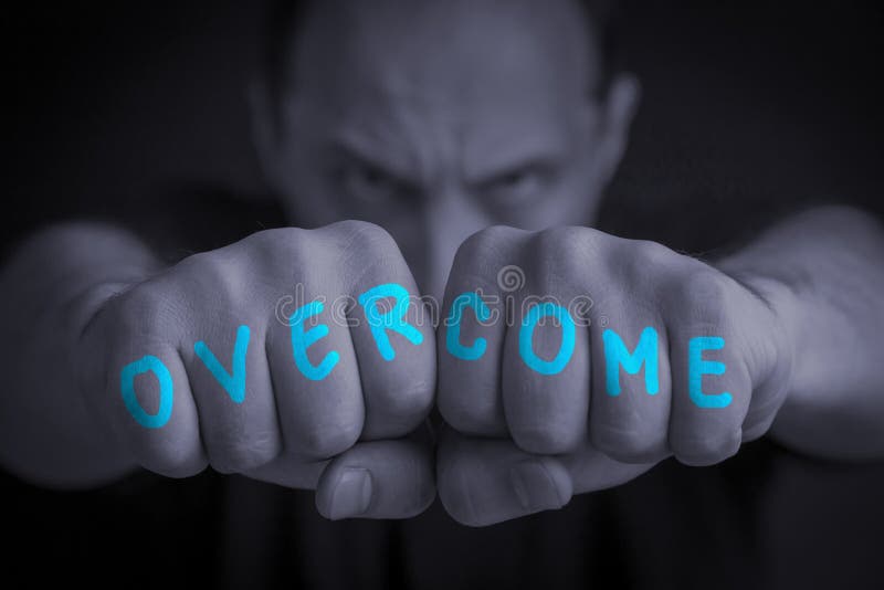 OVERCOME written on the fingers of an angry manâ€™s fists. Gray colored. Message concept image. OVERCOME written on the fingers of an angry manâ€™s fists. Gray colored. Message concept image.