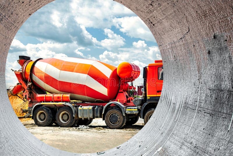 Concrete mixer truck in front of a concrete batching plant, cement factory. Loading concrete mixer truck. Close-up. Delivery of concrete to the construction site. Monolithic concrete works. Concrete mixer truck in front of a concrete batching plant, cement factory. Loading concrete mixer truck. Close-up. Delivery of concrete to the construction site. Monolithic concrete works.