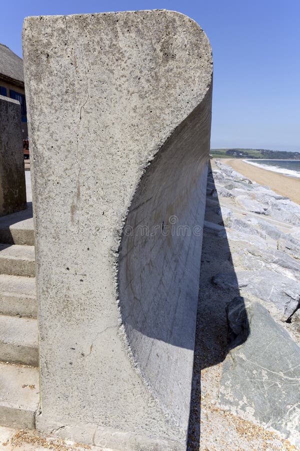 Massive concrete concave wall on the seafront acts a a defense against waves during winter storms. Massive concrete concave wall on the seafront acts a a defense against waves during winter storms
