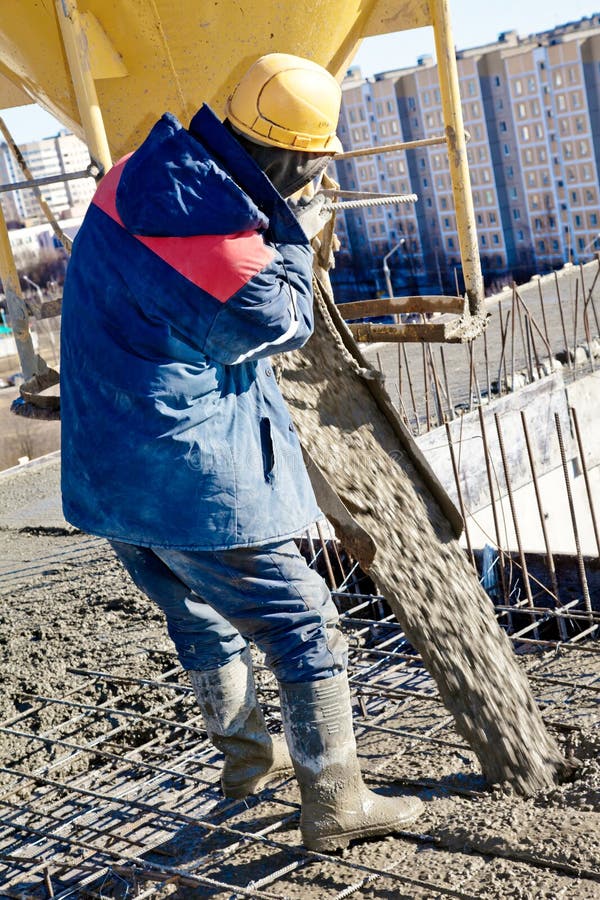 Builder worker in hard helmet and uniform during concrete pouring works at construction site. Builder worker in hard helmet and uniform during concrete pouring works at construction site