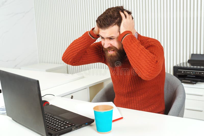 Betonter bärtiger Mannholdingkopf mit seiner Hand am Arbeitsplatz Mann, der Laptop betrachtet Manager, der Problem, schlechte Nac lizenzfreie stockbilder Betonter bärtiger Mannholdingkopf mit seiner Hand am Arbeitsplatz Mann, der Laptop betrachtet Manager, der Problem, schlechte Nac lizenzfreie stockbilder