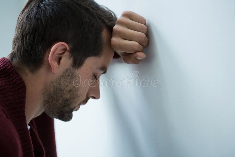 Betonter Mann, der auf Wand sich lehnt stockfotografie Betonter Mann, der auf Wand sich lehnt stockfotografie