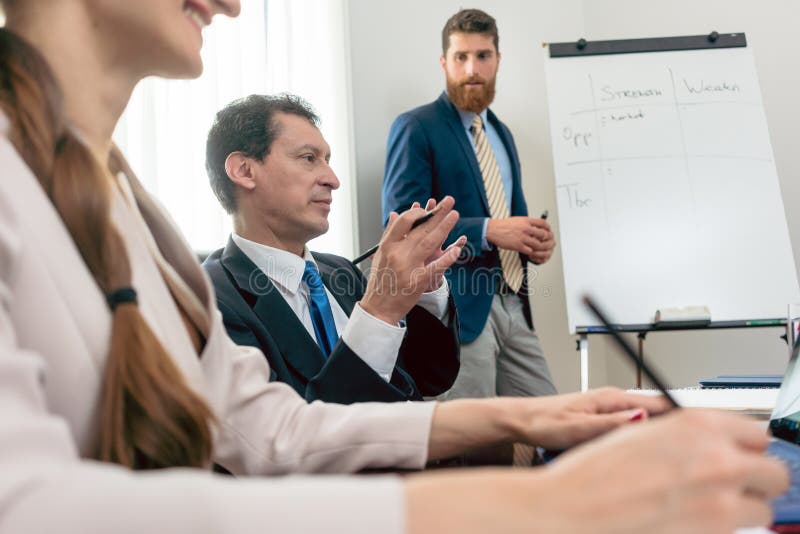 Betrouwbare deskundige die een SWOT analyse leiden tijdens raad van beheer royalty-vrije stock afbeelding Betrouwbare deskundige die een SWOT analyse leiden tijdens raad van beheer royalty-vrije stock afbeelding