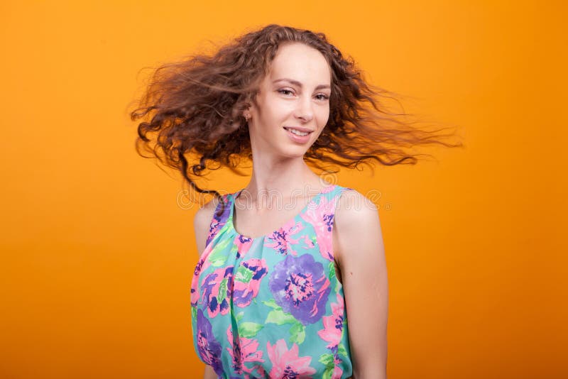 Betrouwbare jonge vrouw die haar prachtige haar in haar studio trilt stock afbeelding Betrouwbare jonge vrouw die haar prachtige haar in haar studio trilt stock afbeelding