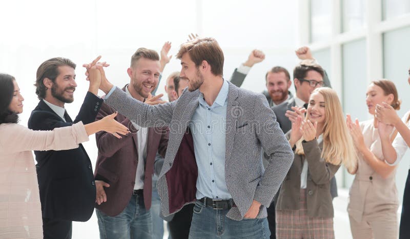 Close up. cheerful employees congratulating a colleague on the promotion. success concept. Close up. cheerful employees congratulating a colleague on the promotion. success concept