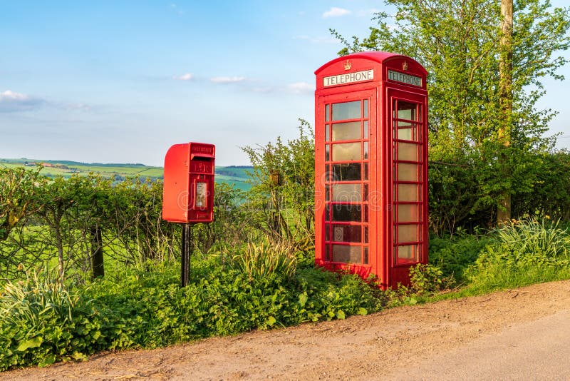 Bettws-y-crwyn, Shropshire, England, UK - May 06, 2018: An old telephone booth and a letterbox on the side of a rural road. Bettws-y-crwyn, Shropshire, England, UK - May 06, 2018: An old telephone booth and a letterbox on the side of a rural road