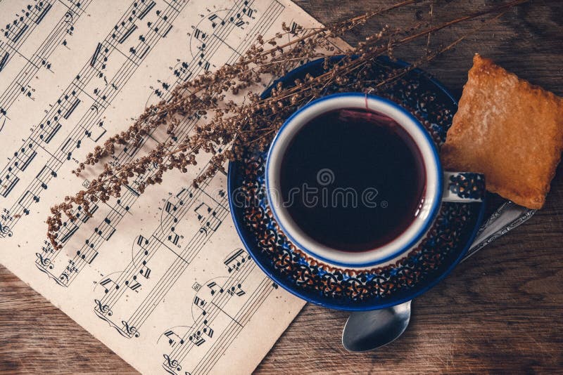 Bevanda e biscotto caldi con le note musicali e le foglie di autunno su una superficie di legno della tavola Vista superiore immagini stock libere da diritti Bevanda e biscotto caldi con le note musicali e le foglie di autunno su una superficie di legno della tavola Vista superiore immagini stock libere da diritti