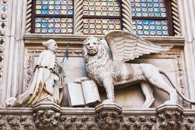 Bevingat lejon och en präst Detail av slotten Palazzo Ducale för doge` s i Venedig, Italien arkivbilder Bevingat lejon och en präst Detail av slotten Palazzo Ducale för doge` s i Venedig, Italien arkivbilder