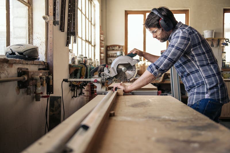 Bewerkt het timmermans scherpe hout met zaag in zijn workshop in verstek