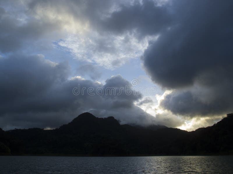 Bewolkte zonsondergang over bergmeer Spectaculaire stormachtige wolken onder zonlicht stock afbeeldingen Bewolkte zonsondergang over bergmeer Spectaculaire stormachtige wolken onder zonlicht stock afbeeldingen
