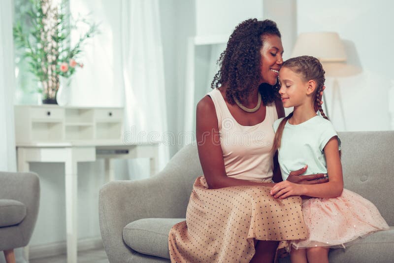 Bezaubernde liebevolle afroe-amerikanisch Mutter, die zart recht süße kleine Tochter umarmt stockfotos