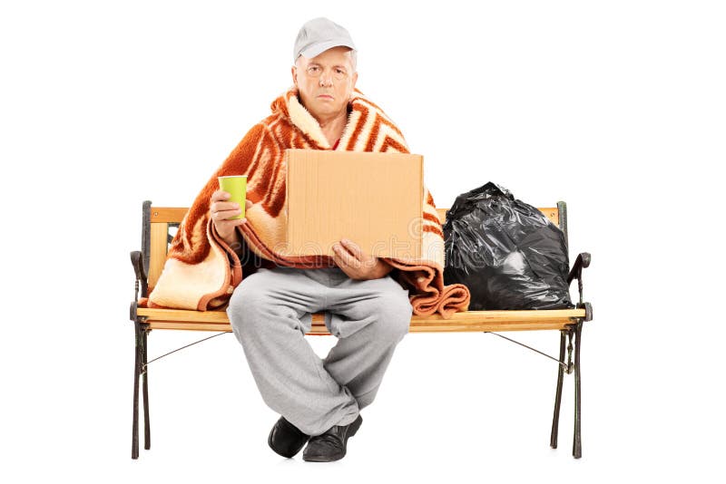 Homeless mature man sitting on a bench, his worldly possessions next to him, holding a blank cardboard isolated on white background. Homeless mature man sitting on a bench, his worldly possessions next to him, holding a blank cardboard isolated on white background