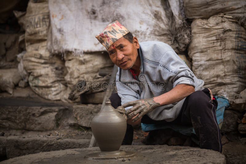 BHAKTAOUR, NEPAL - Nepalese man working in the his pottery workshop royalty free stock image