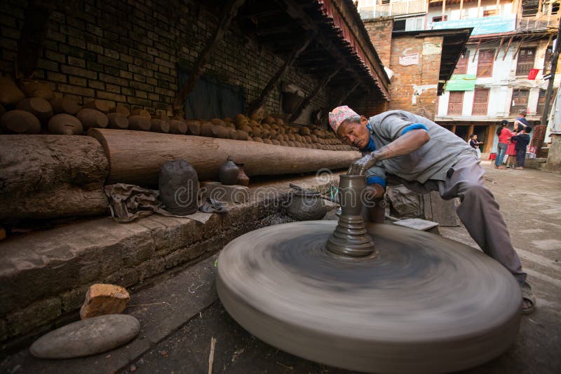 BHAKTAOUR, NEPAL - Unidentified Nepalese man working in the his pottery workshop stock image