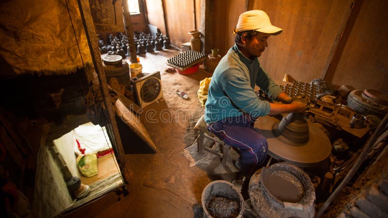 BHAKTAPUR, NEPAL - Nepalese man working in the his pottery workshop. stock image