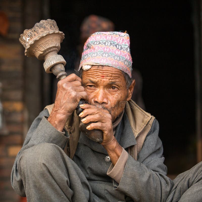 BHAKTAPUR, NEPAL - Portrait of unidentified Nepalese man smokes on the street. stock photos
