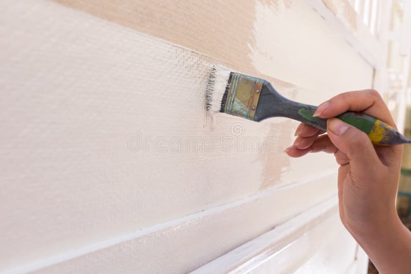 Bianco di verniciatura della spazzola della tenuta del lavoratore della mano immagini stock libere da diritti Bianco di verniciatura della spazzola della tenuta del lavoratore della mano immagini stock libere da diritti