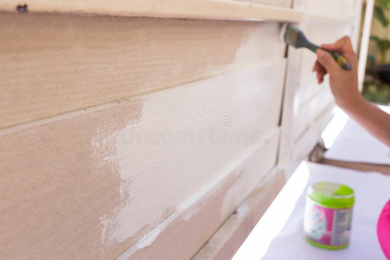 Bianco di verniciatura della spazzola della tenuta del lavoratore della mano fotografia stock Bianco di verniciatura della spazzola della tenuta del lavoratore della mano fotografia stock