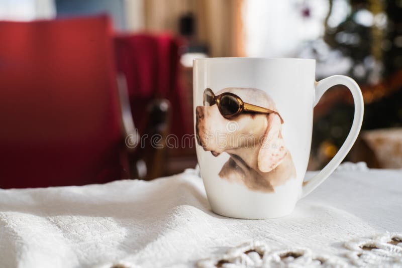 Biała filiżanka z fotografią pies z czarnymi eyeglasses na białej zakładce