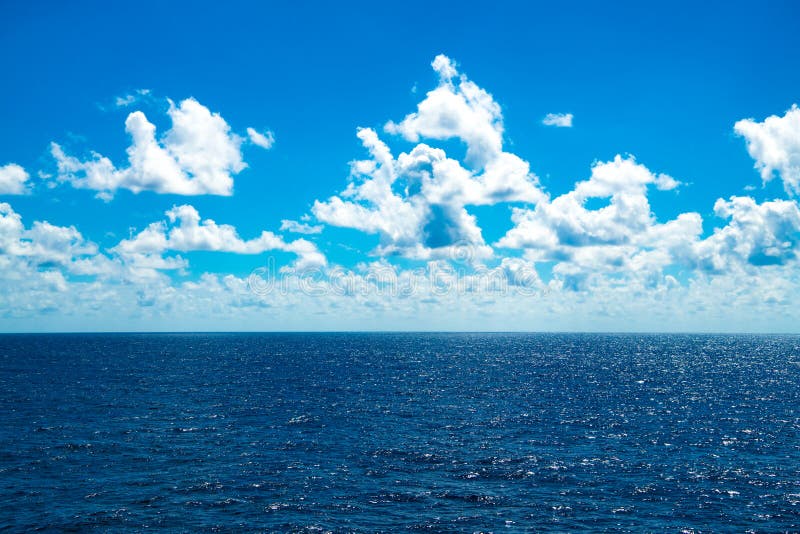 Białe chmury na niebieskim niebie nad jasną, musującą wodą oceanu północnego atlantyckiego zdjęcia stock