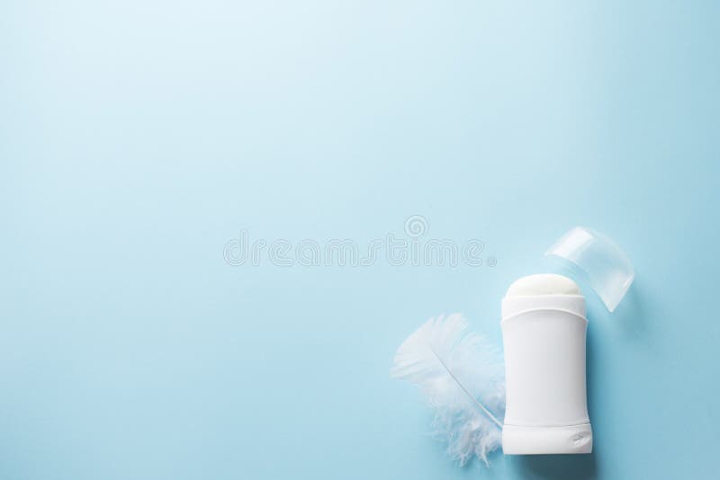 Biały antiperspirant z piórkiem na błękitnym tle dla ciało skóry opieki pojęcia lub dezodorant kosmos kopii zdjęcia royalty free