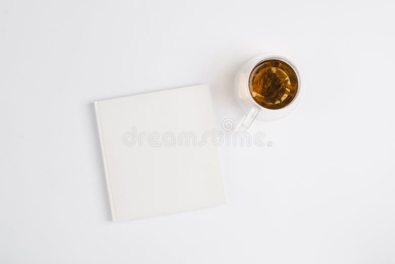 Biały notes z filiżanką herbaty na białym minimalnym tle. koncepcja celów i planów na nowy rok fotografia royalty free