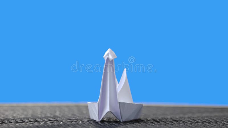 Biały origami łabędź na błękitnym tle