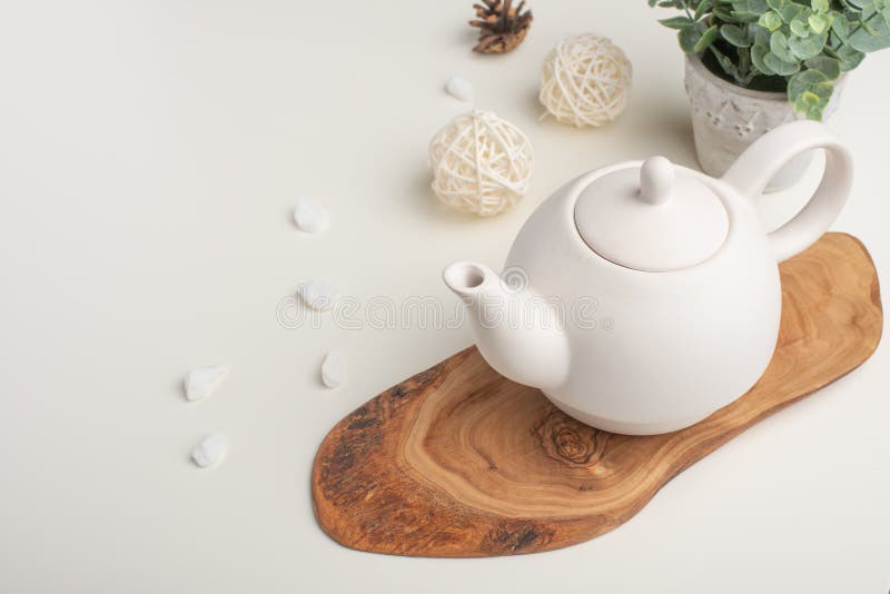 Biały porcelany teapot z akcesoriami na drewnianej desce na białym stole na widok kosmos kopii obraz stock Biały porcelany teapot z akcesoriami na drewnianej desce na białym stole na widok kosmos kopii obraz stock