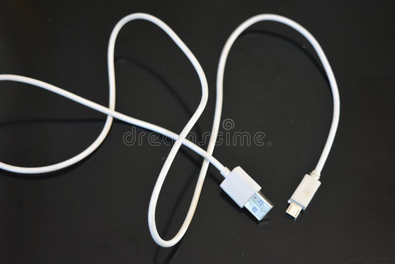 Biały przewód długi dla sprzętu komputerowego i biurowego, złącze USB na czarnej błyszczącej powierzchni fotografia royalty free Biały przewód długi dla sprzętu komputerowego i biurowego, złącze USB na czarnej błyszczącej powierzchni fotografia royalty free