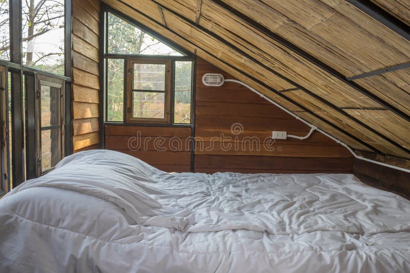 White Bed and Work Table in Country Loft  Interior Design Room. Interior design room include chair and lamp and windows and curtain. Interior design room in part of bedroom. White Bed and Work Table in Country Loft  Interior Design Room. Interior design room include chair and lamp and windows and curtain. Interior design room in part of bedroom