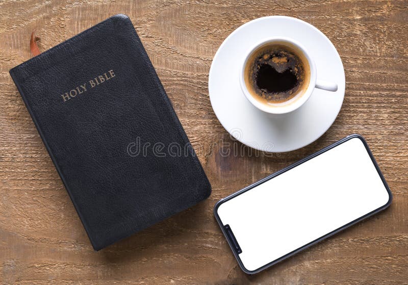 Bibbia santa e smartphone con la tazza di caffè nero fotografie stock