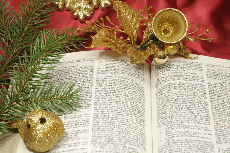 Bible open to the Christmas passage of Luke 2 with evergreen and gold decor. Bible open to the Christmas passage of Luke 2 with evergreen and gold decor