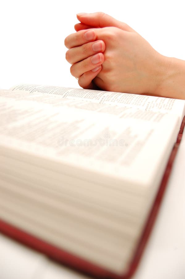 Praying hands on an open bible