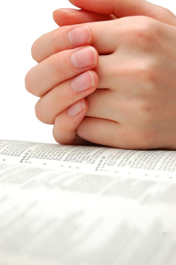 Praying hands on an open bible